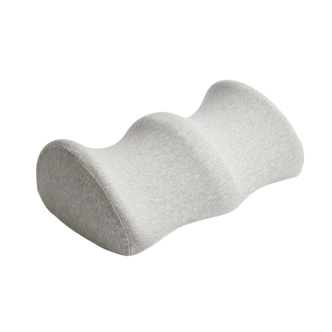 The iCare Reform Knee Support - Elevation for Pressure Relief is a contoured, charcoal-infused foam leg pillow with three grooves, designed to support the knees and promote proper spinal alignment during sleep.